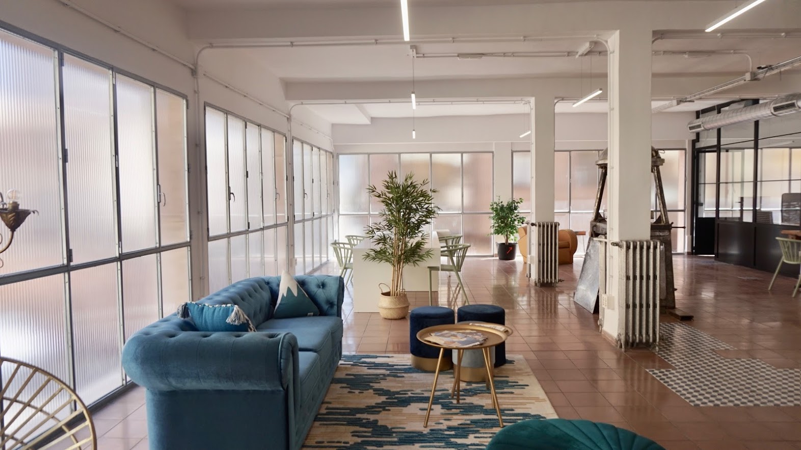 Espacio abierto con sofá, mesa de trabajo y decoraciones estilo vintage